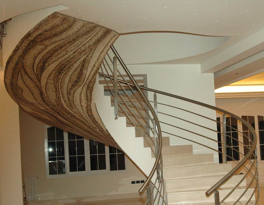 Curving staircase with a sweeping mosaic-clad wall following the line of the steps
