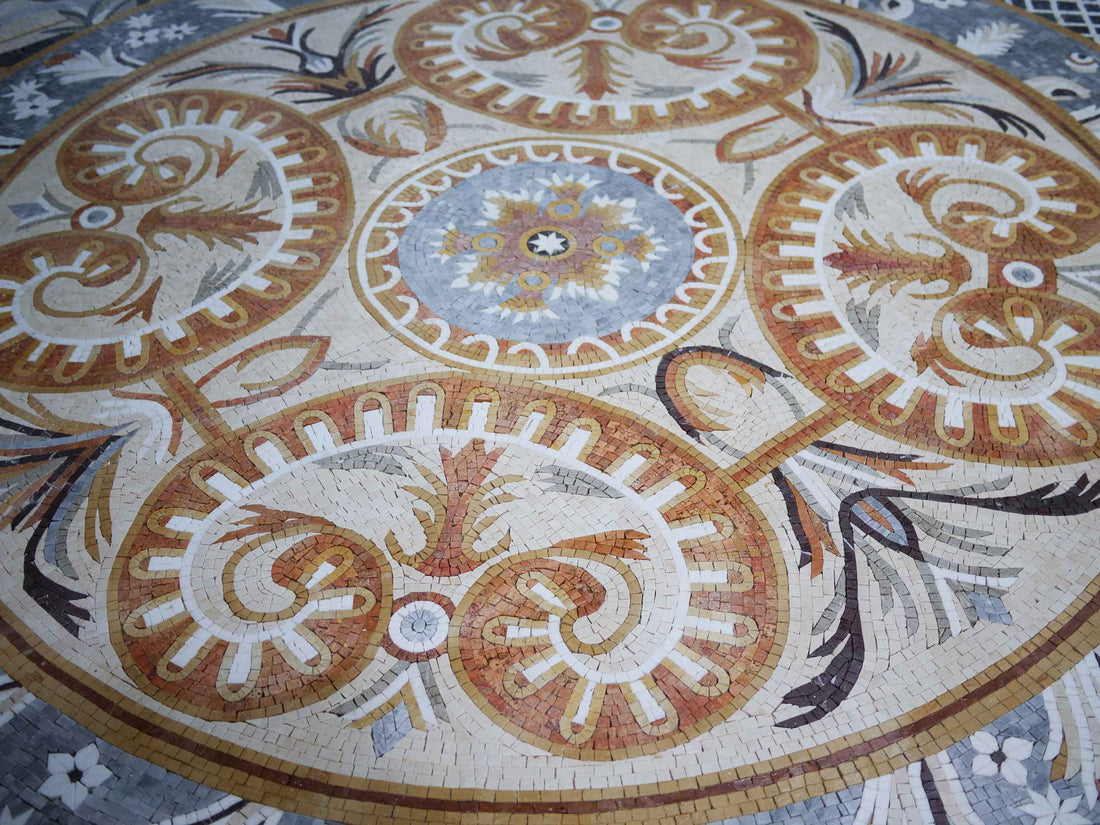 Round mosaic coaster with a scrolling leaf pattern in ochre and blue