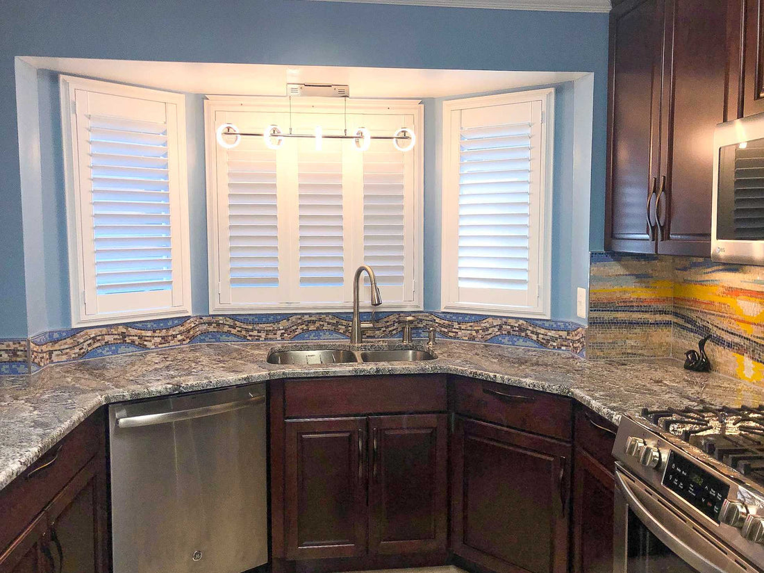 Kitchen corner with dark wood cabinets, a granite counter and a shuttered bay window