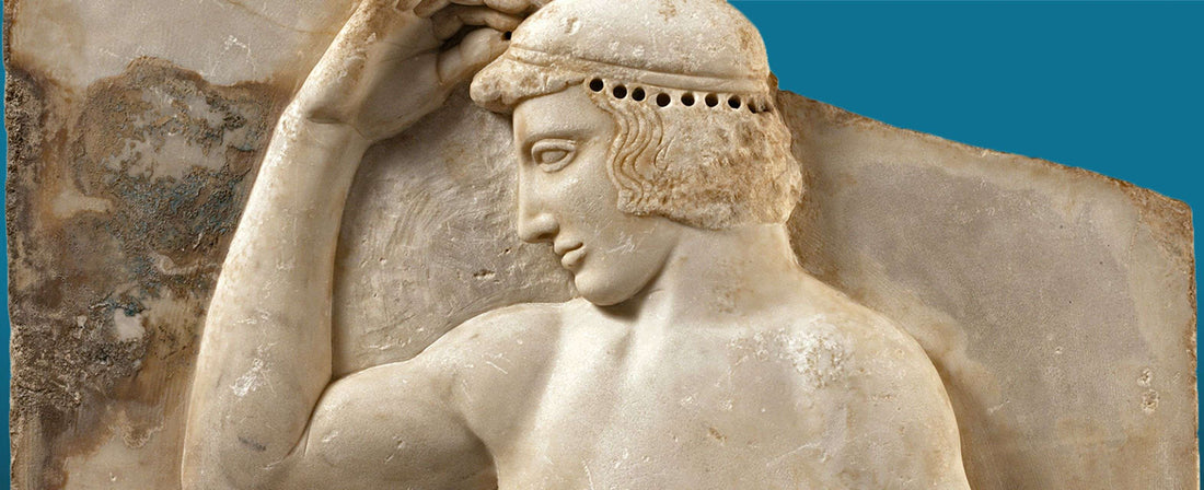 Carved marble figure raising a hand to the head, photographed against a teal background