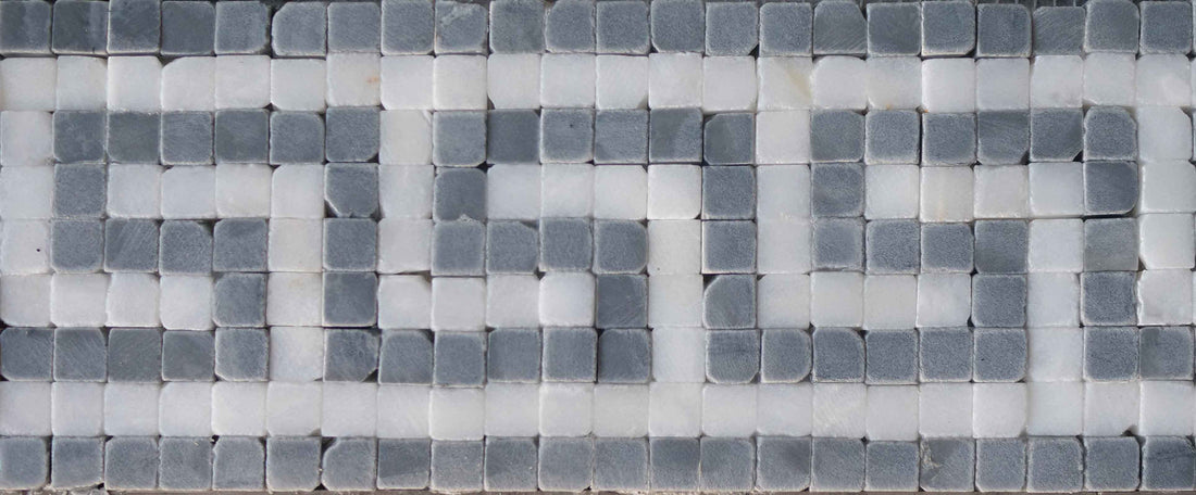 Grey and white marble mosaic border in a repeating Greek key pattern